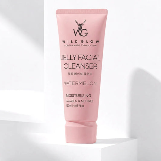 A pink squeeze tube of Wild Glow Jelly Facial Cleanser Watermelon, standing upright on a white geometric platform against a white background with soft shadows.
