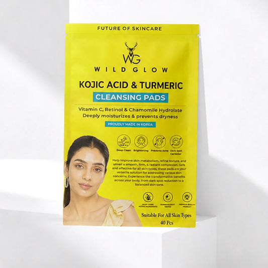 Wild Glow Kojic Acid & Turmeric Cleansing Pads in a bright yellow stand-up pouch, displayed on a white geometric platform with soft shadows.