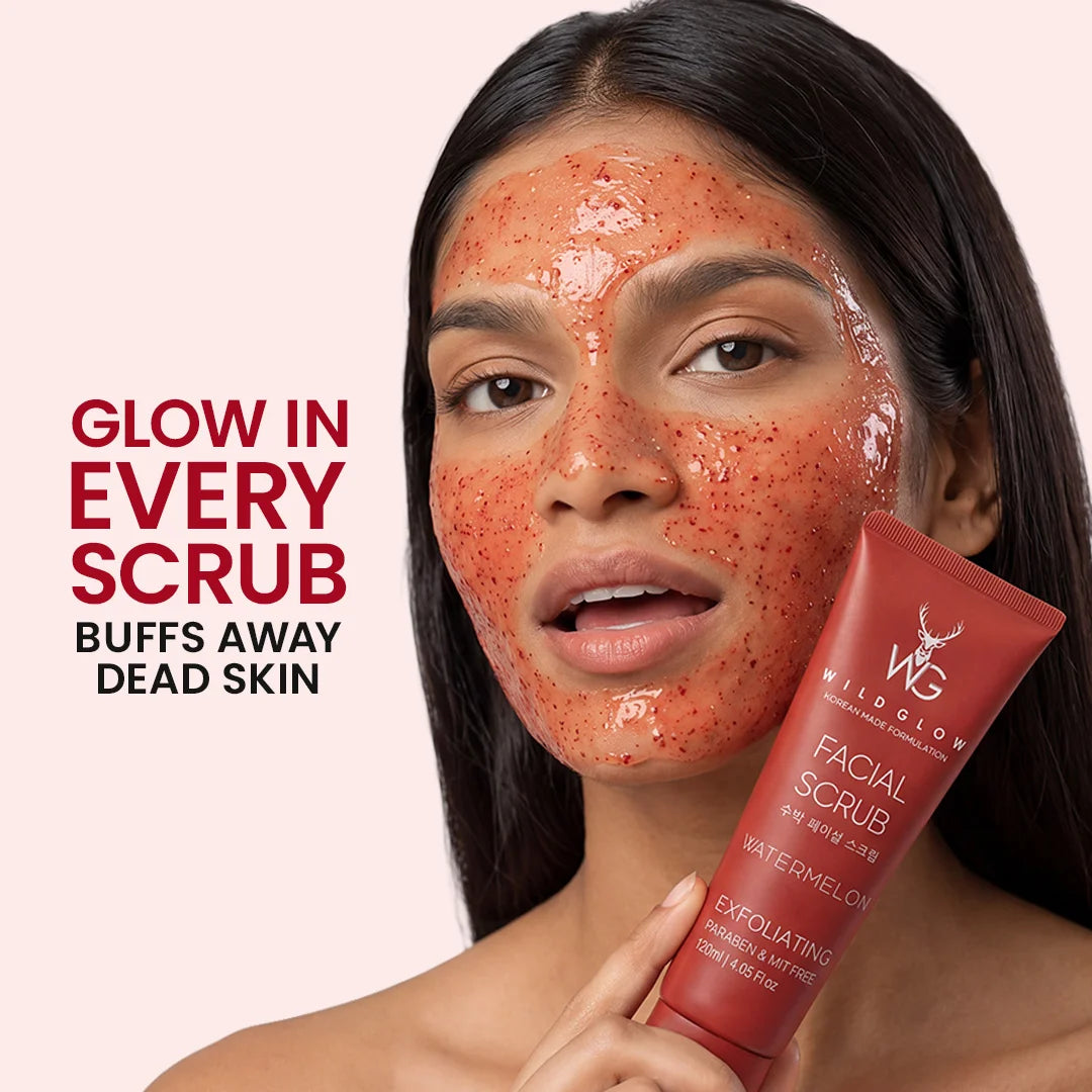 A woman with a red exfoliating facial scrub applied to her face holds a red tube of WG Wild Glow Facial Scrub against a pale pink background with promotional text.